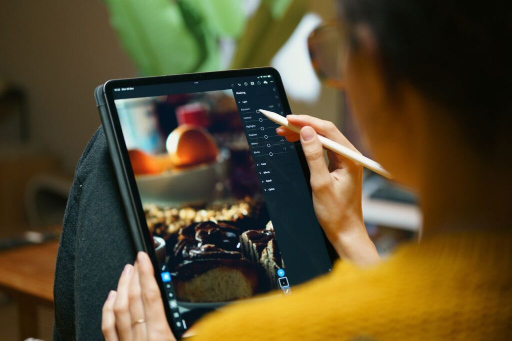 Video Editing Tips for Beginners: The Ultimate Guide to Creating Professional Videos A woman uses a stylus to edit photos on a tablet, showcasing EDITING FOR BEGINER